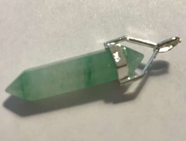 The Natural Serenity Aventurine Silver Pendant is a green, faceted, translucent crystal amulet with a silver cap and loop in minimalist style, pointed at both ends and shown on a white surface. The Natural Serenity Aventurine Silver Pendant is a green, faceted, translucent crystal amulet with a silver cap and loop in minimalist style, pointed at both ends and shown on a white surface.